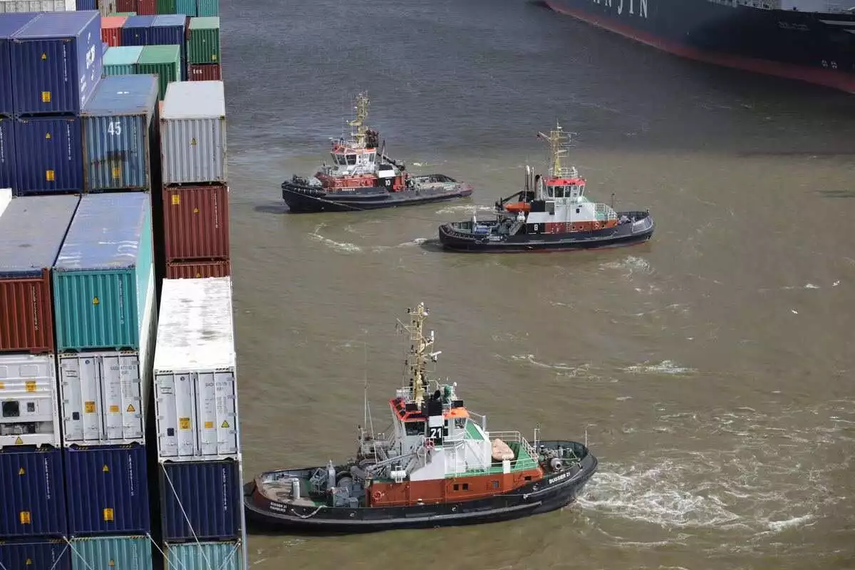 kapal tunda berada di sebelah kapal induk dan siap untuk menarik kapal induk